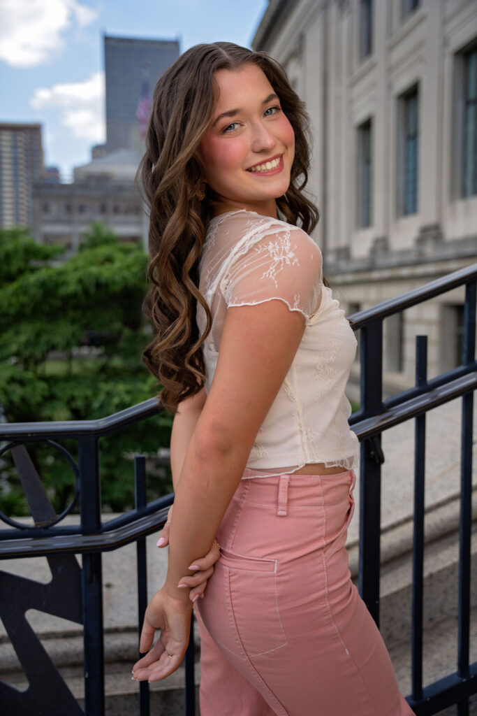 Senior wearing lace and pink posing downtown in New Jersey by photographer Susan Grace