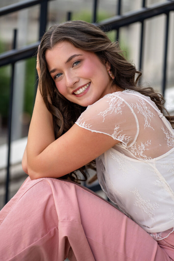 Senior wearing lace and pink posing downtown in New Jersey by photographer Susan Grace